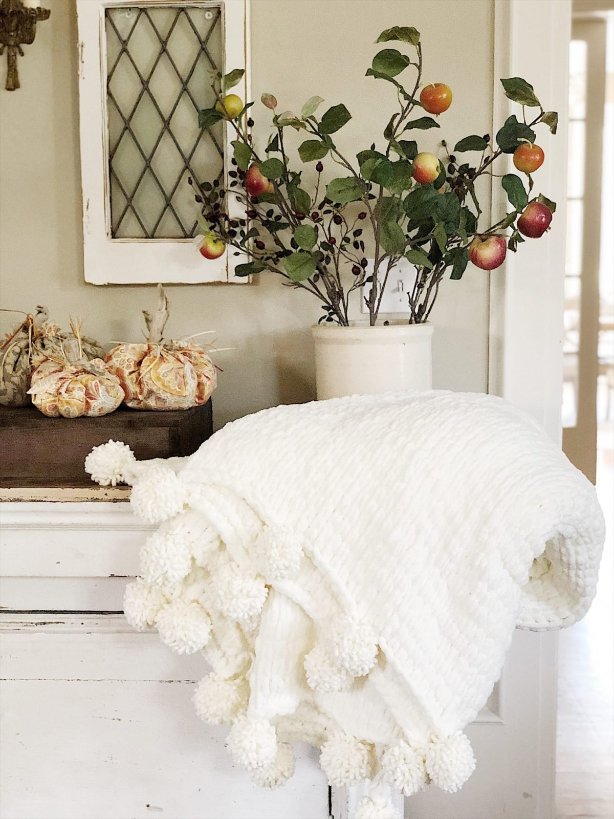 Decorating for fall with pumpkins, florals and chunky blanket.