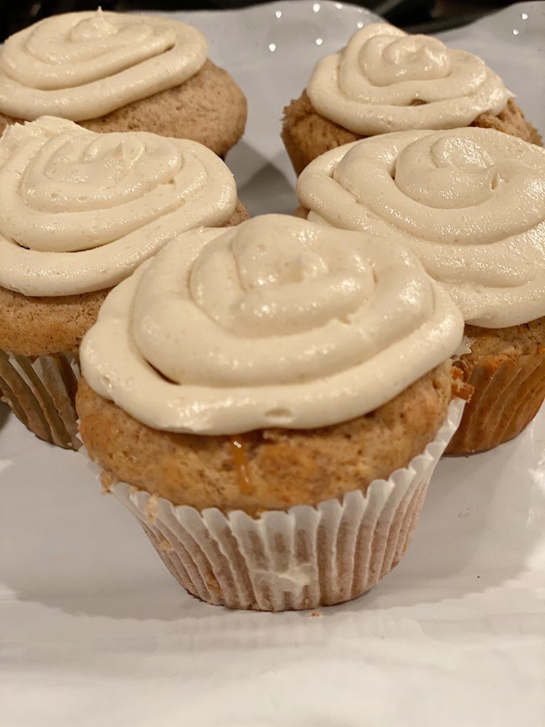 five cupcakes with buttercream cream cheese frosting