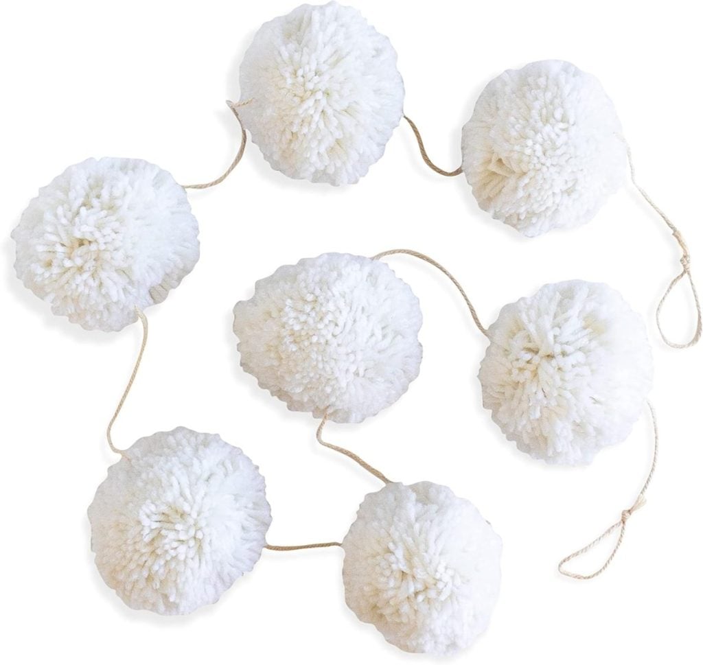 Perfect for a DIY Christmas gift, this charming arrangement features eight white pom-poms connected by a string, elegantly displayed on a white background.