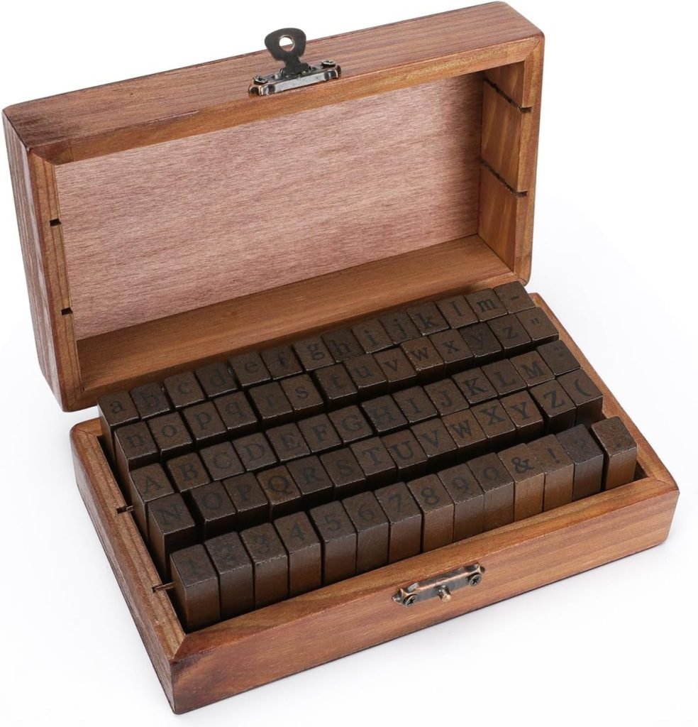 A wooden box, perfect as a DIY Christmas gift, contains a set of letter and number stamps neatly arranged in rows. The box is open, displaying both uppercase and lowercase letters alongside numbers and symbols.