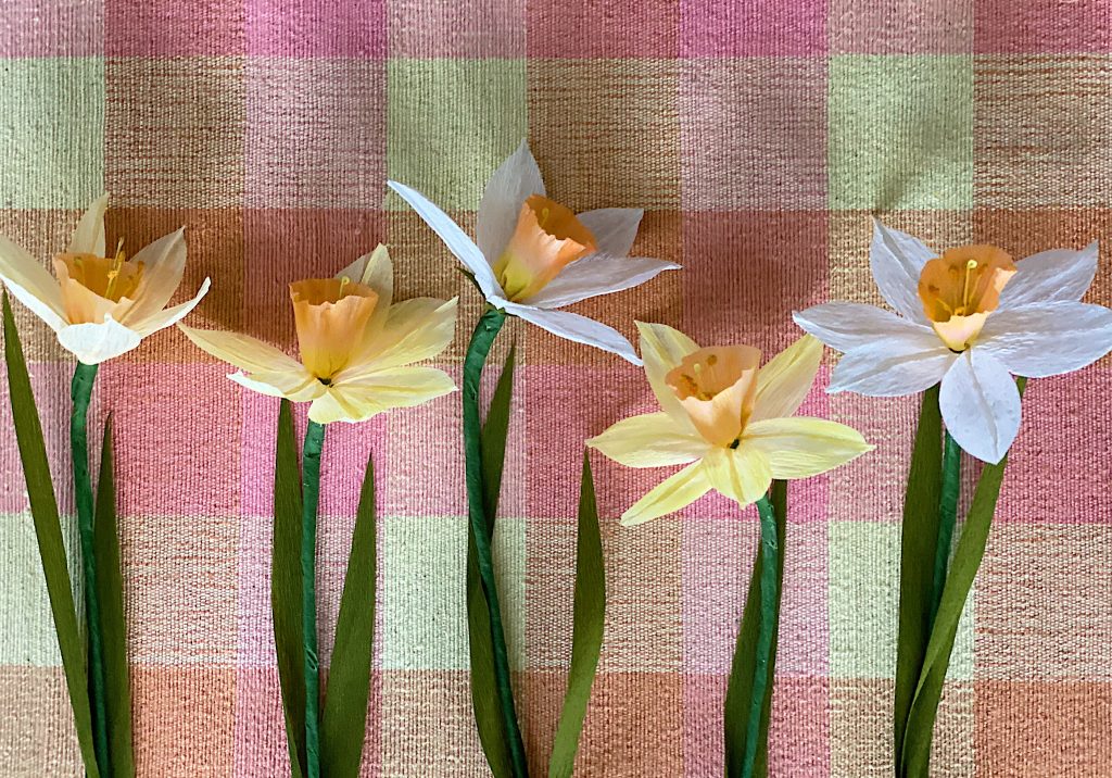 Yellow and White Paper Daffodil Bouquet laid out on a pink, orange and yellow plaid placemat