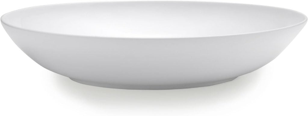 A plain white, shallow ceramic bowl with a smooth finish, ideal for serving tried and true recipes, captured against a white background.