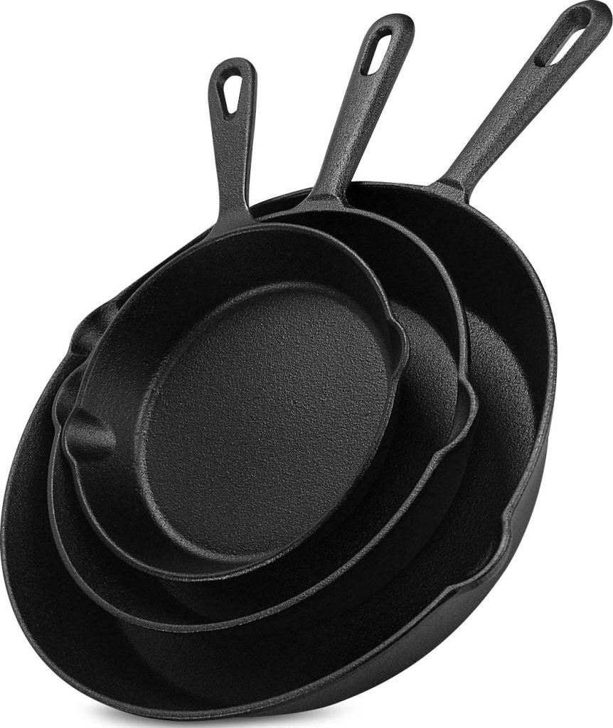 Three black cast iron skillets of varying sizes, stacked inside each other, with handles featuring hanging holes—perfect for preparing your tried and true recipes.