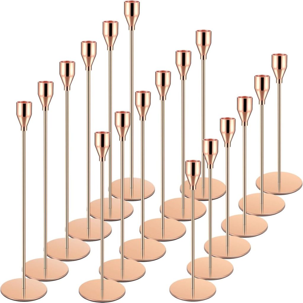 A set of sixteen rose gold metal candle holders of varying heights, each with a round base and cylindrical holder, arranged in rows on a white background—perfect for elevating the Art of Entertaining.