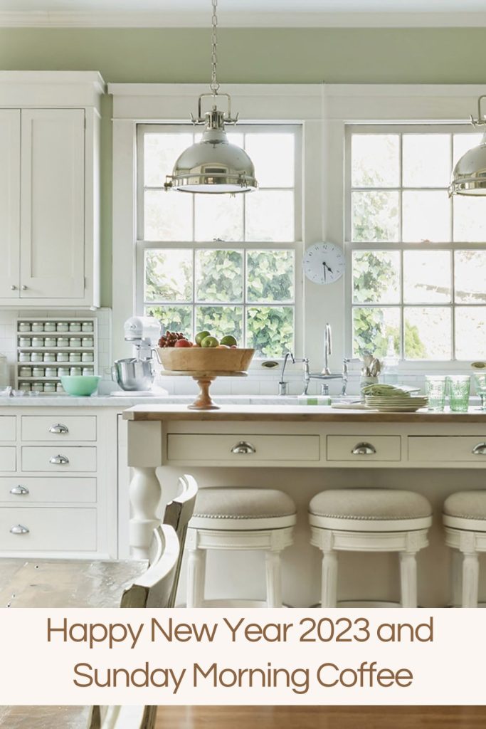 white kitchen with island, sink and windows and bowl with fruit