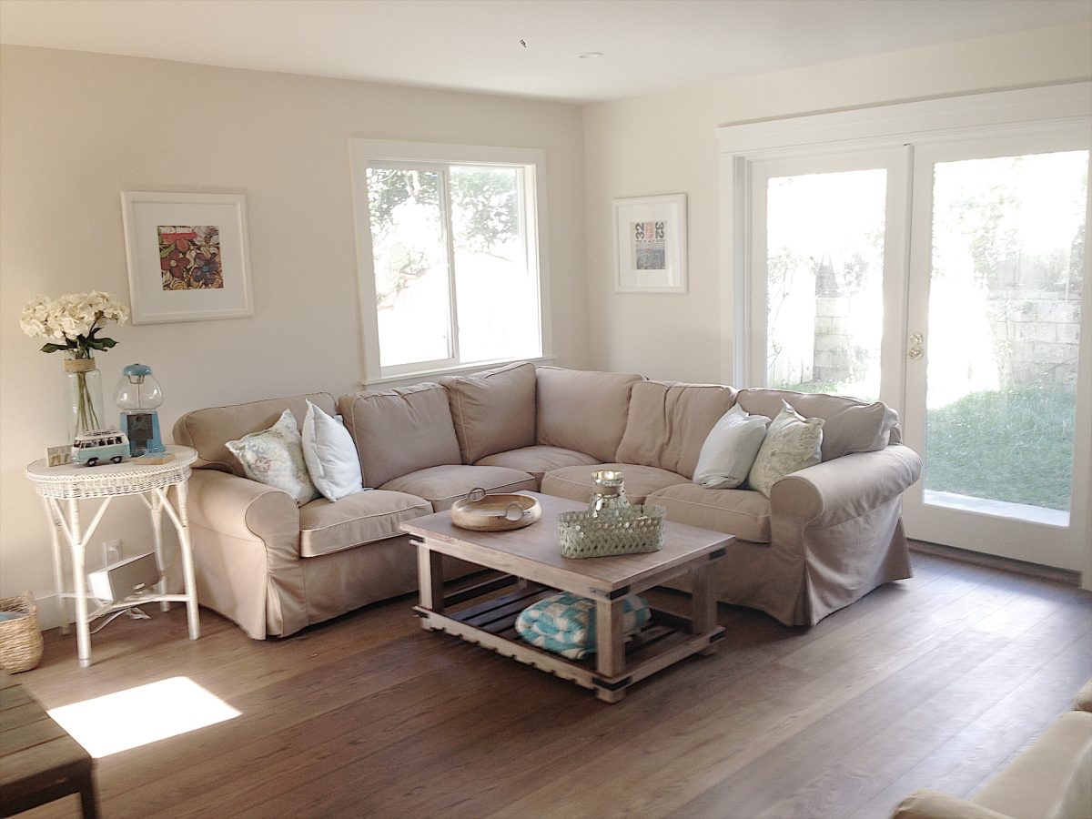 beach house downstairs family room with sectional couch and table