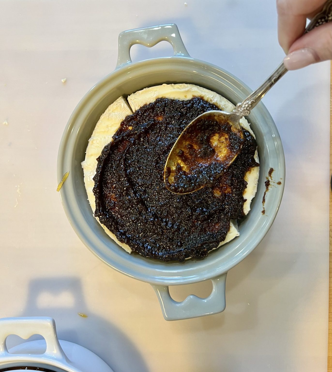 brie baker with brie and fig jam being spread on top