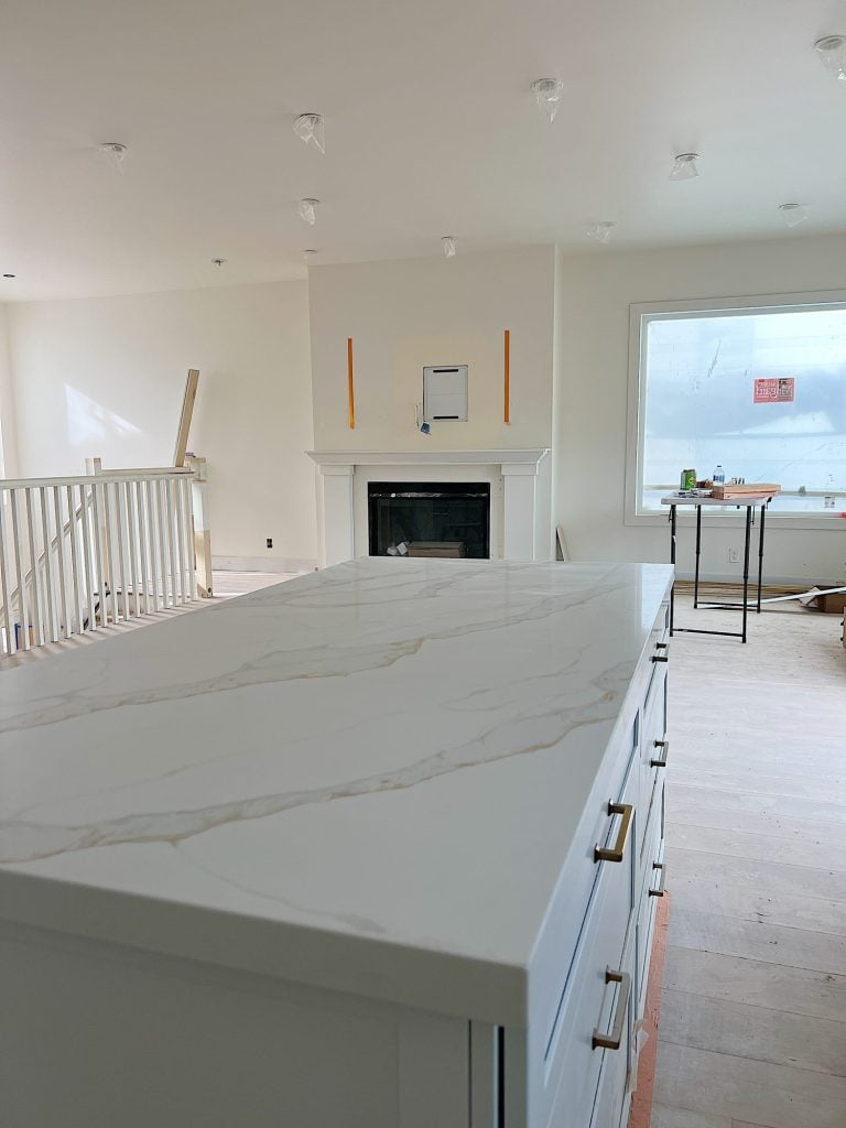 White, tan and gray quartz countertop on the island and family room with white mantle