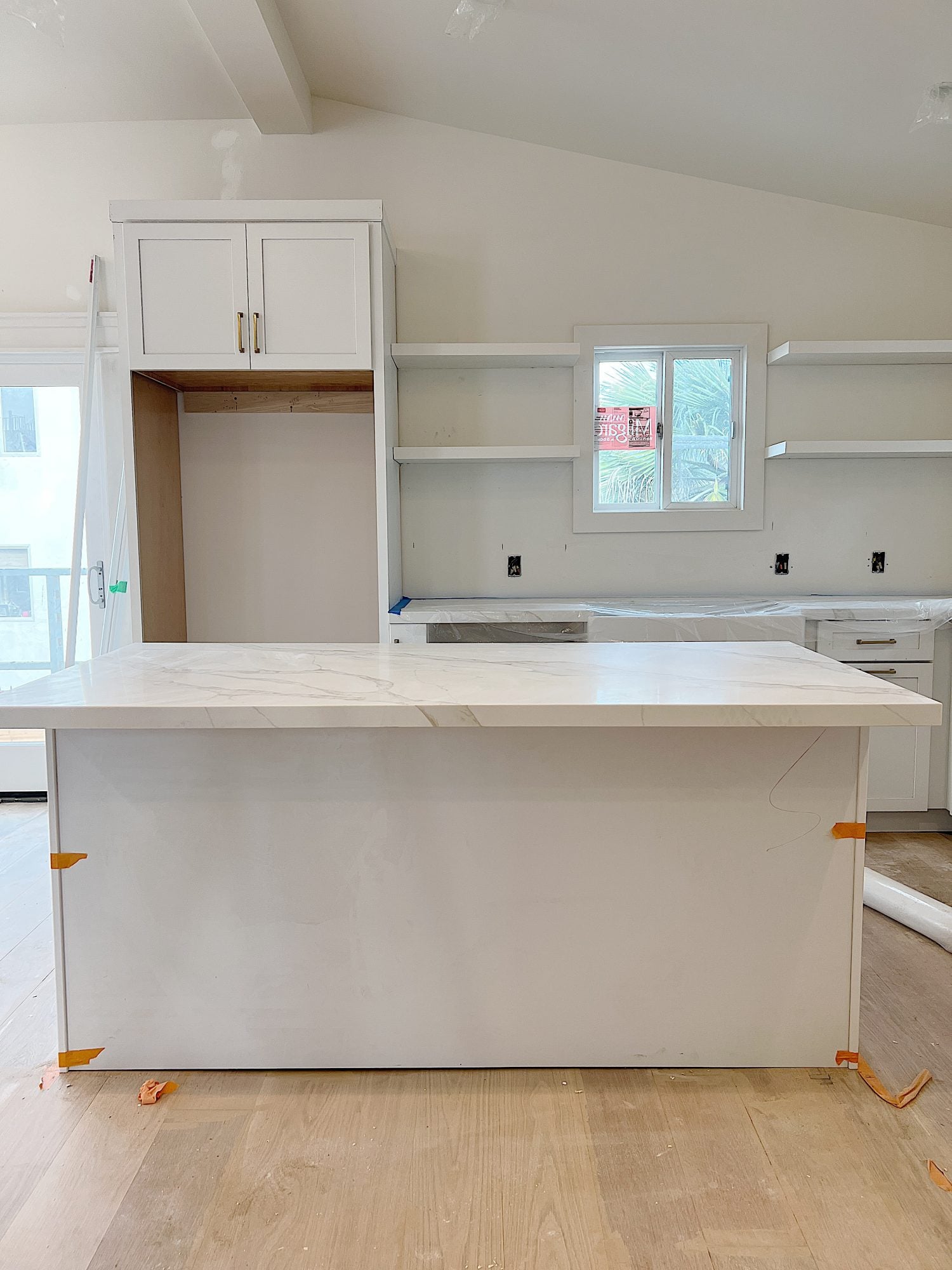 White, tan and gray quartz countertop on the island and cabinets in the beach house kitchen