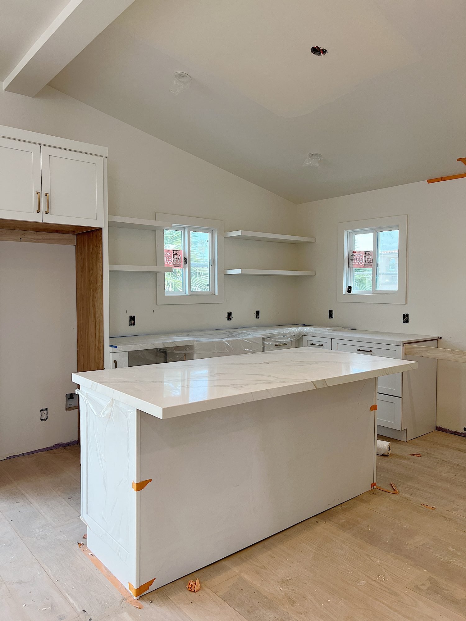 White, tan and gray quartz countertop on the island and cabinets in the beach house kitchen