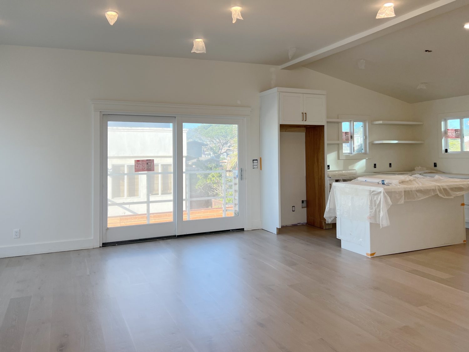 white kitchen at the beach house with new light wood floors and white cabinets.