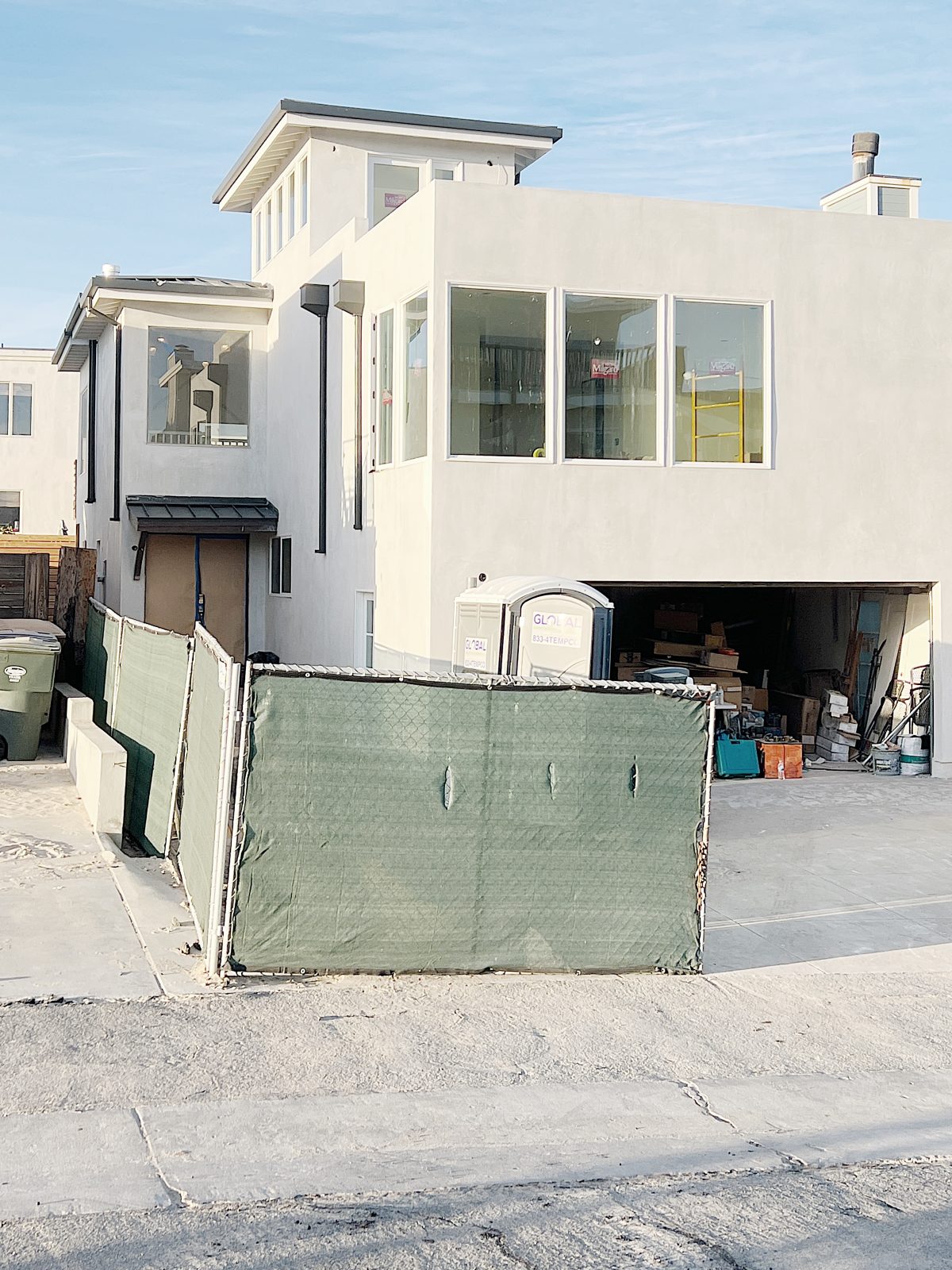 new beach house with white plaster exterior, windows and this floor deck on the beach house tour