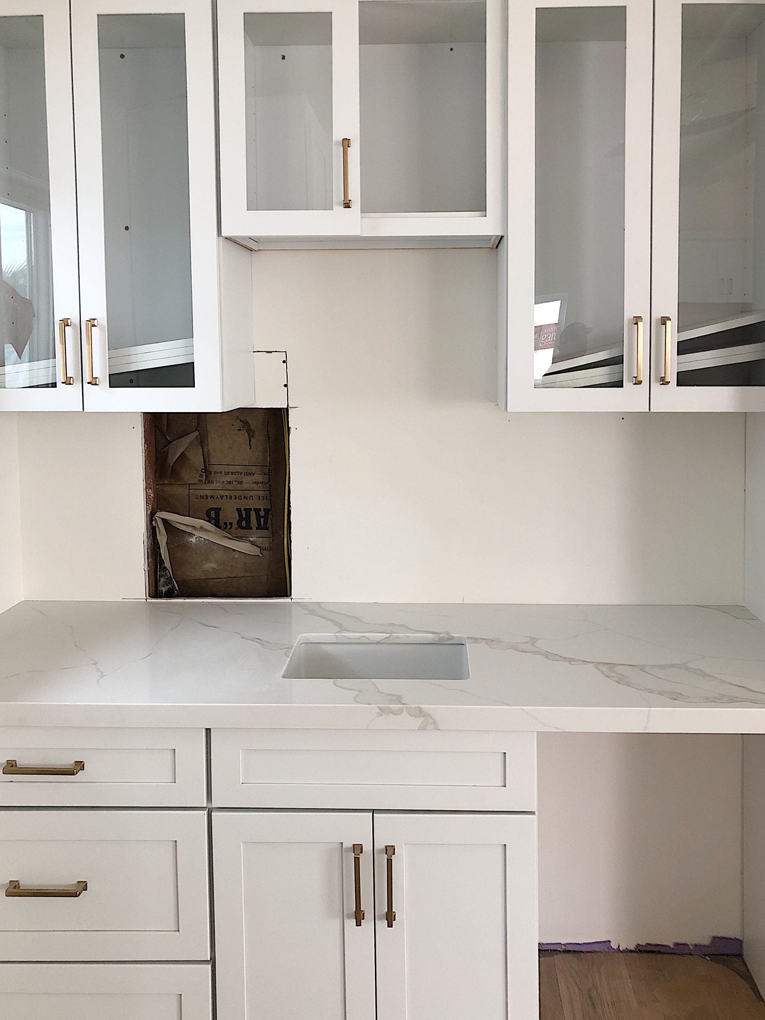White quartz countertops with white upper and lower cabinets.