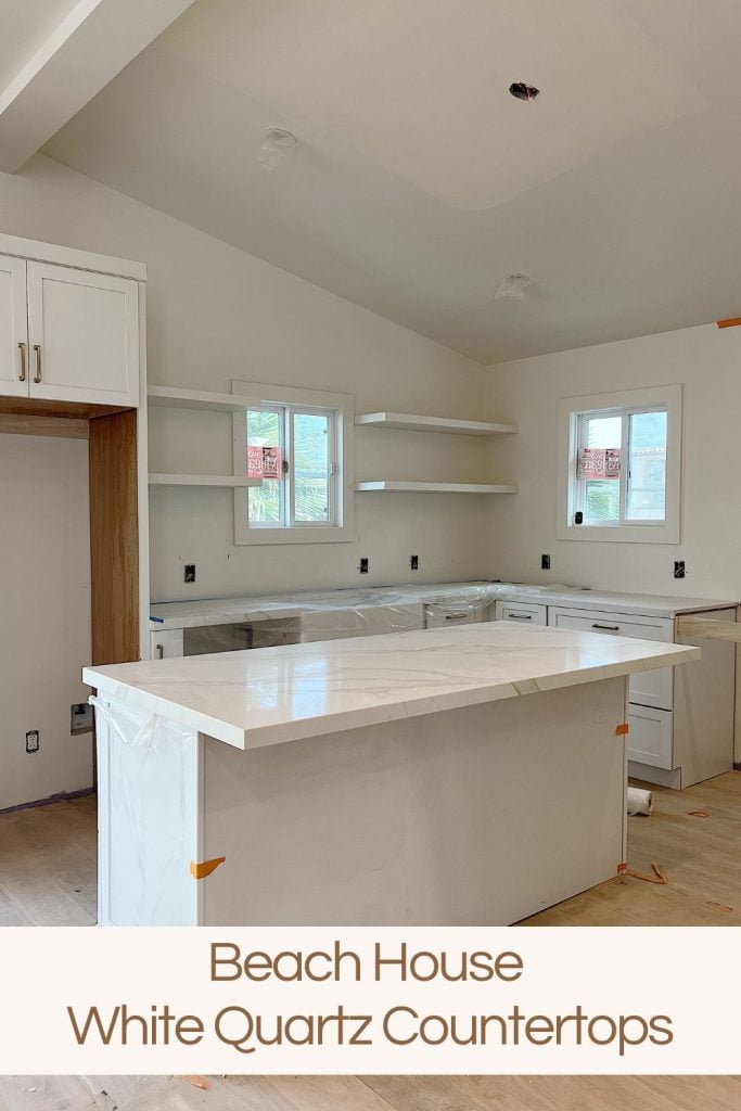 White, tan and gray quartz countertop on the island and cabinets in the beach house kitchen