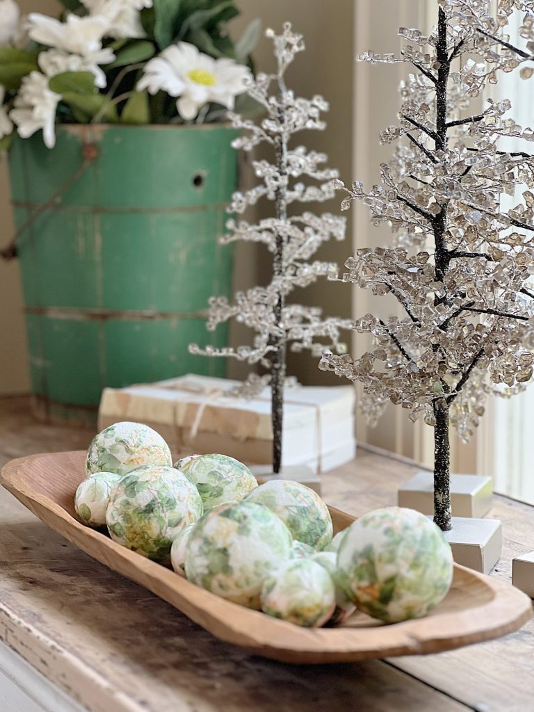 table with green palce settings decorated with green apples, wood balls, and decor balls