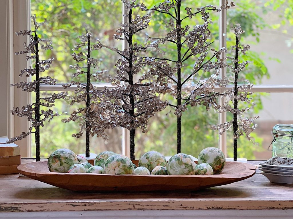 table with green palce settings decorated with green apples, wood balls, and decor balls