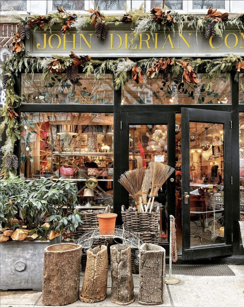 NYC storefront photo of John Derian Company. Winter decorations on storefront with large windows showing contents of store