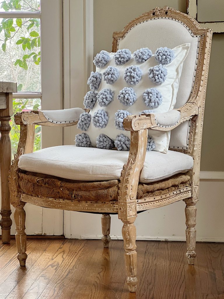 chair with pillow with blue pom poms