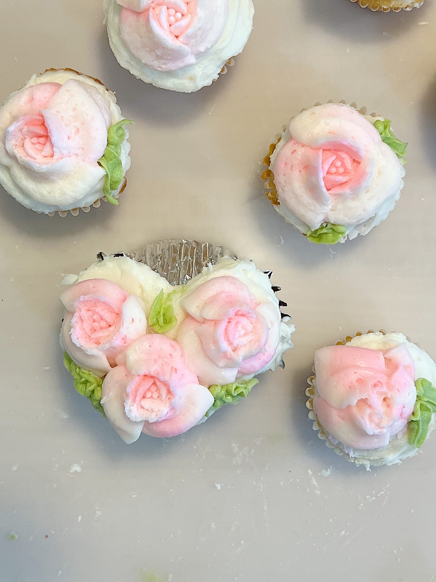 cupcakes decorated with white and pink buttercream frosting