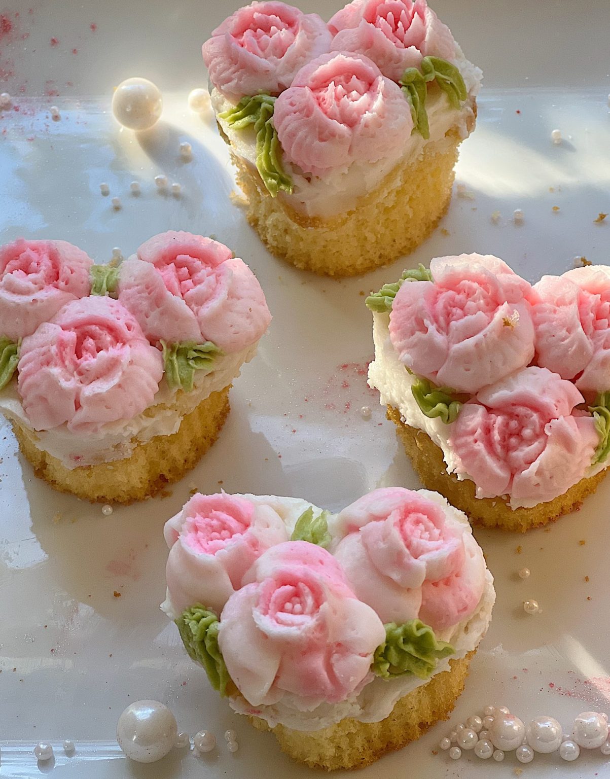 cupcakes decorated with white and pink buttercream frosting