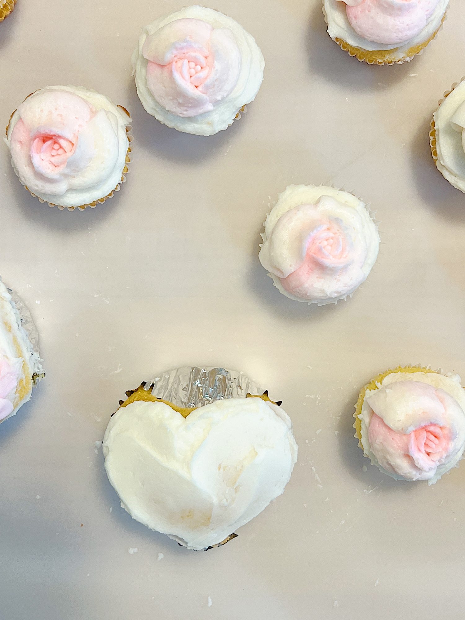 cupcakes decorated with white and pink buttercream frosting