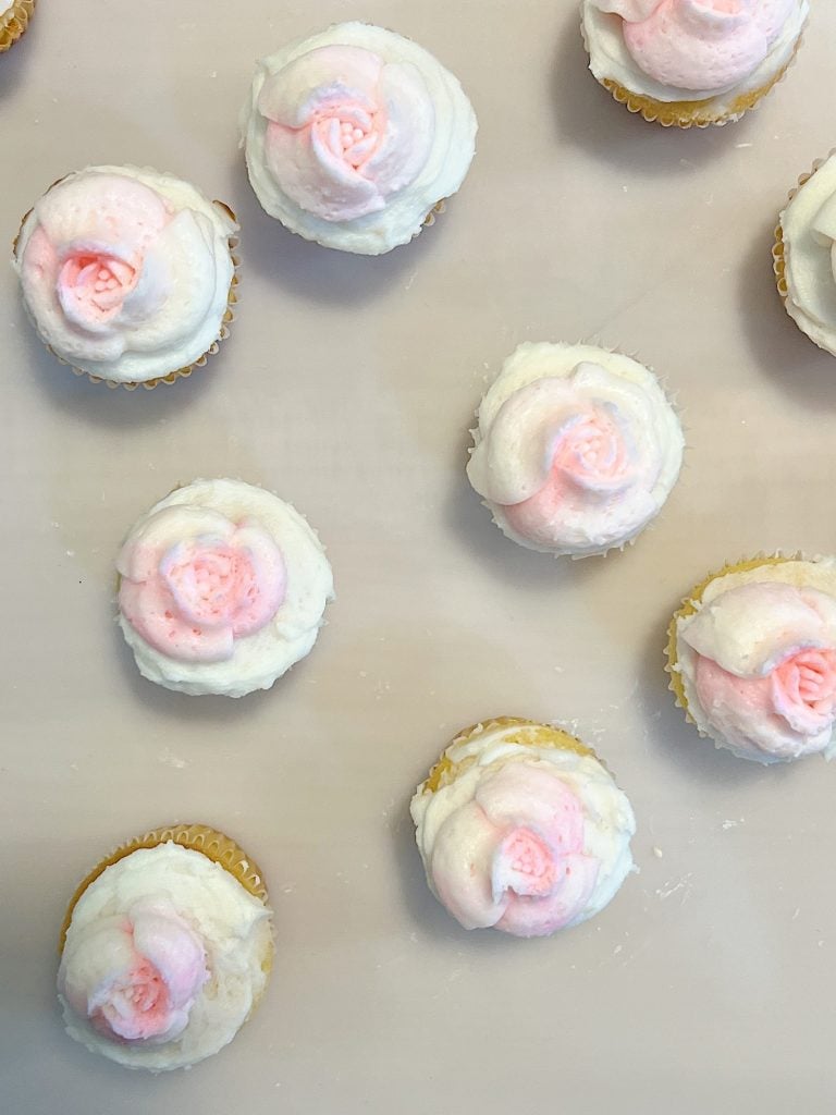 cupcakes decorated with white and pink buttercream frosting