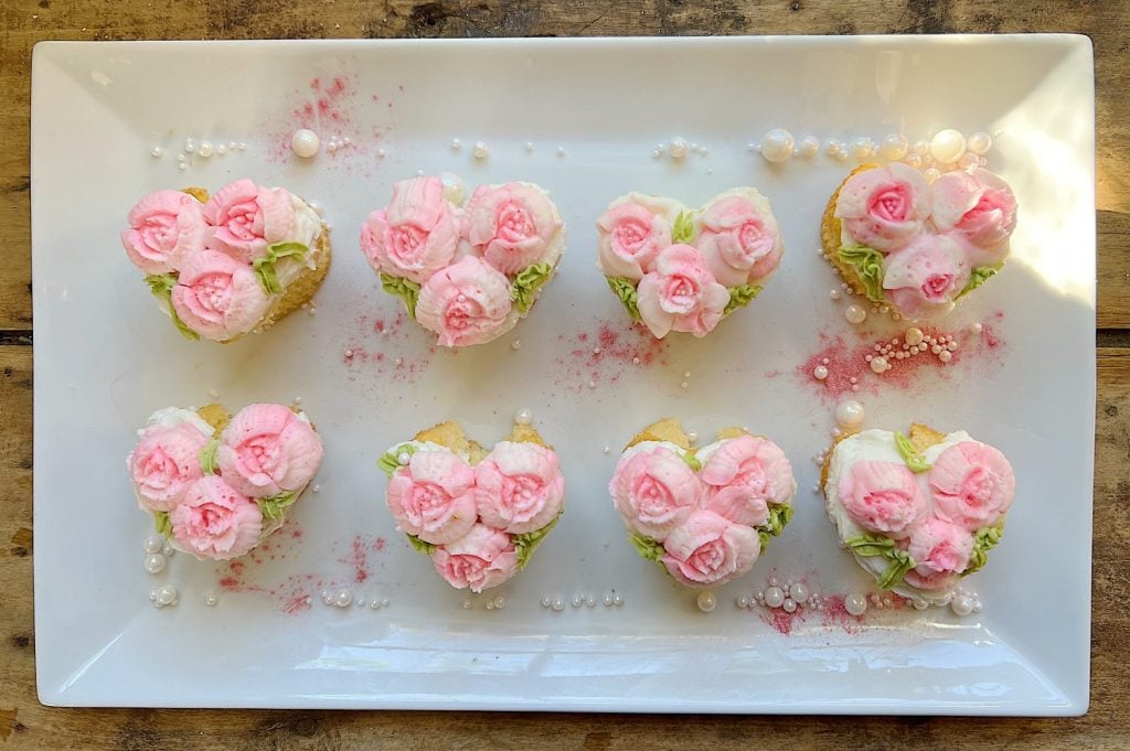 cupcakes decorated with white and pink buttercream frosting