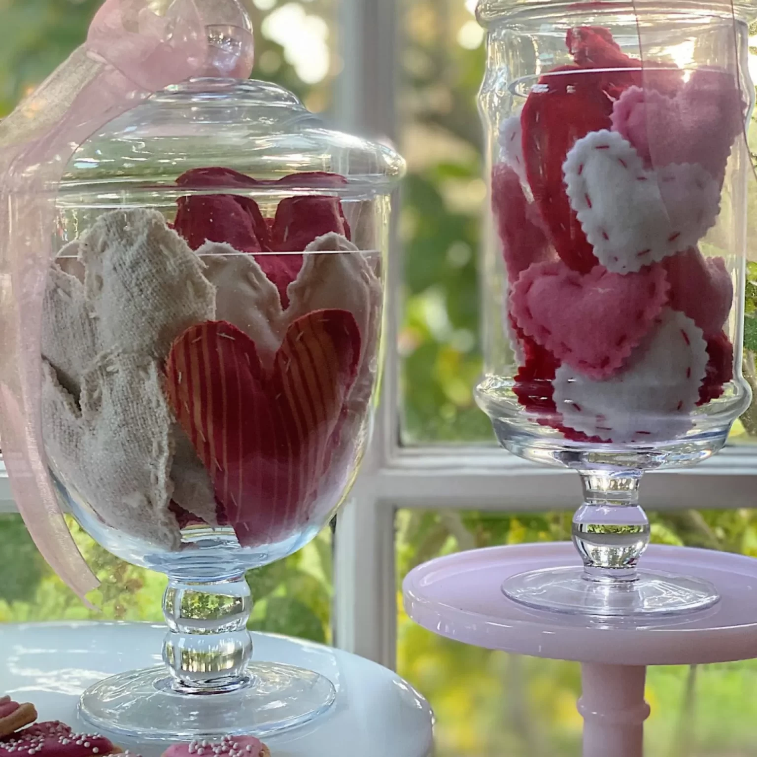 Valentine handmade fabric hearts in two glass apothecary jars.