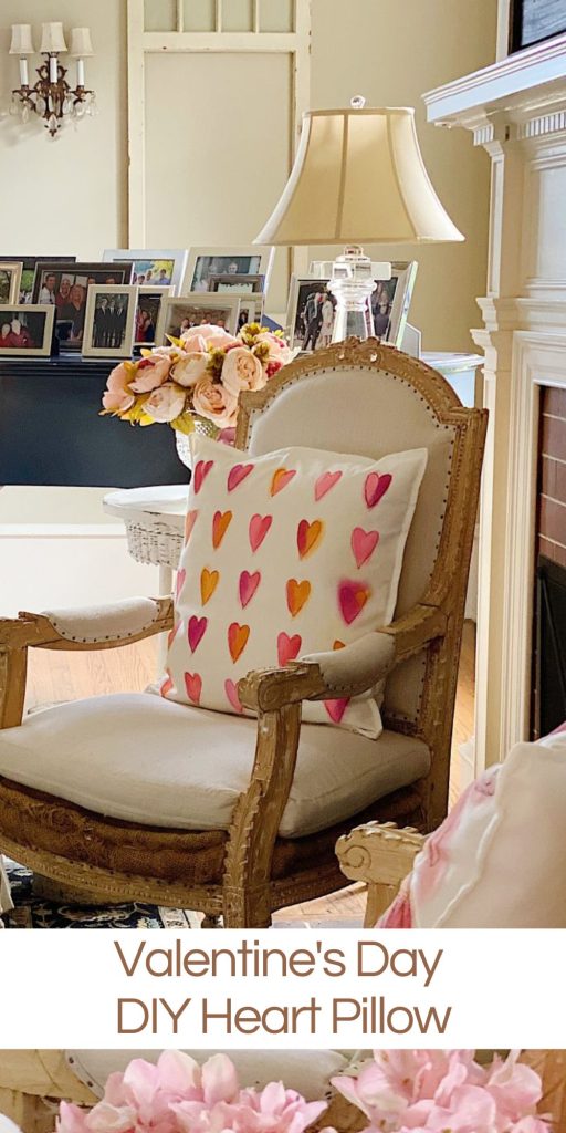 heart painted pillow on a white wood chair in a living room