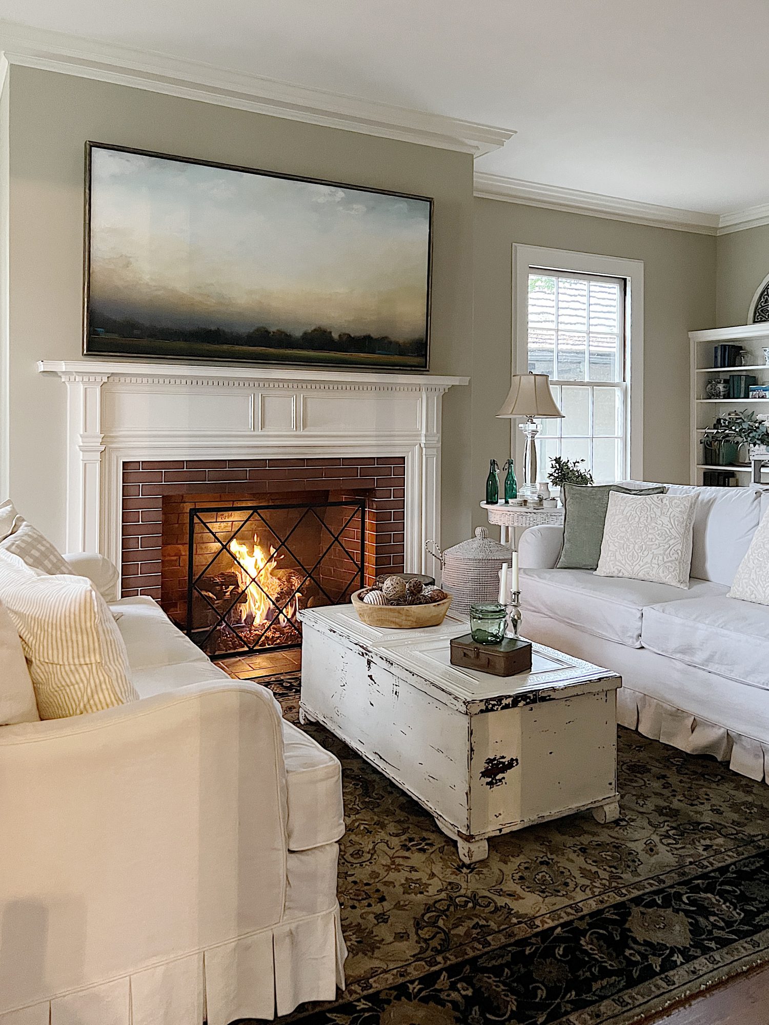 living room with white coach, white coffee table, decor and fire in the fireplace