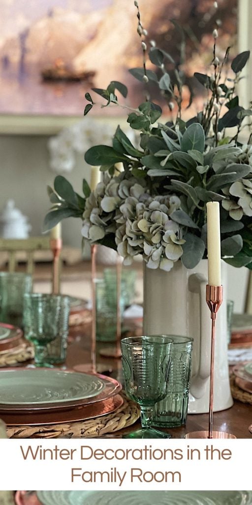table set with hyacinth placemat, copper charger, green plate, green glasses, copper candlesticks, and green flowers in a vase