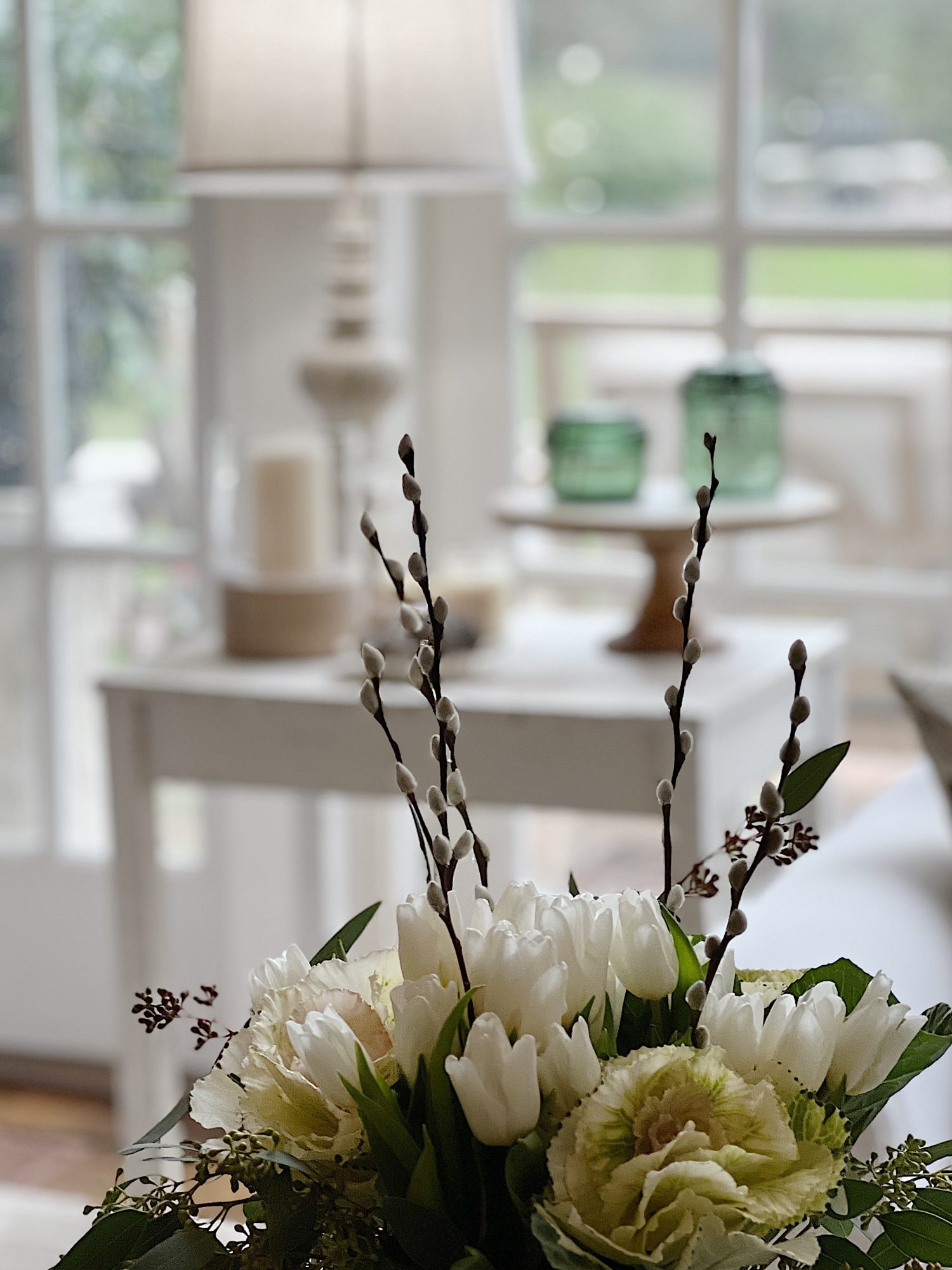 end table with lamp, green jars and candle. Coffee table with flowers