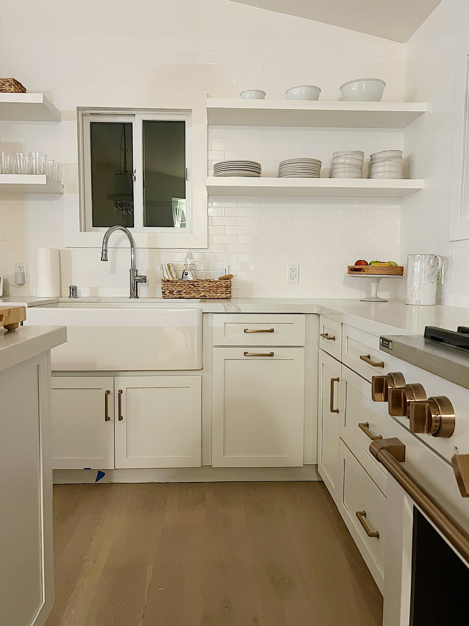 white kitcehn with white cabinets, countertops and open shelves
