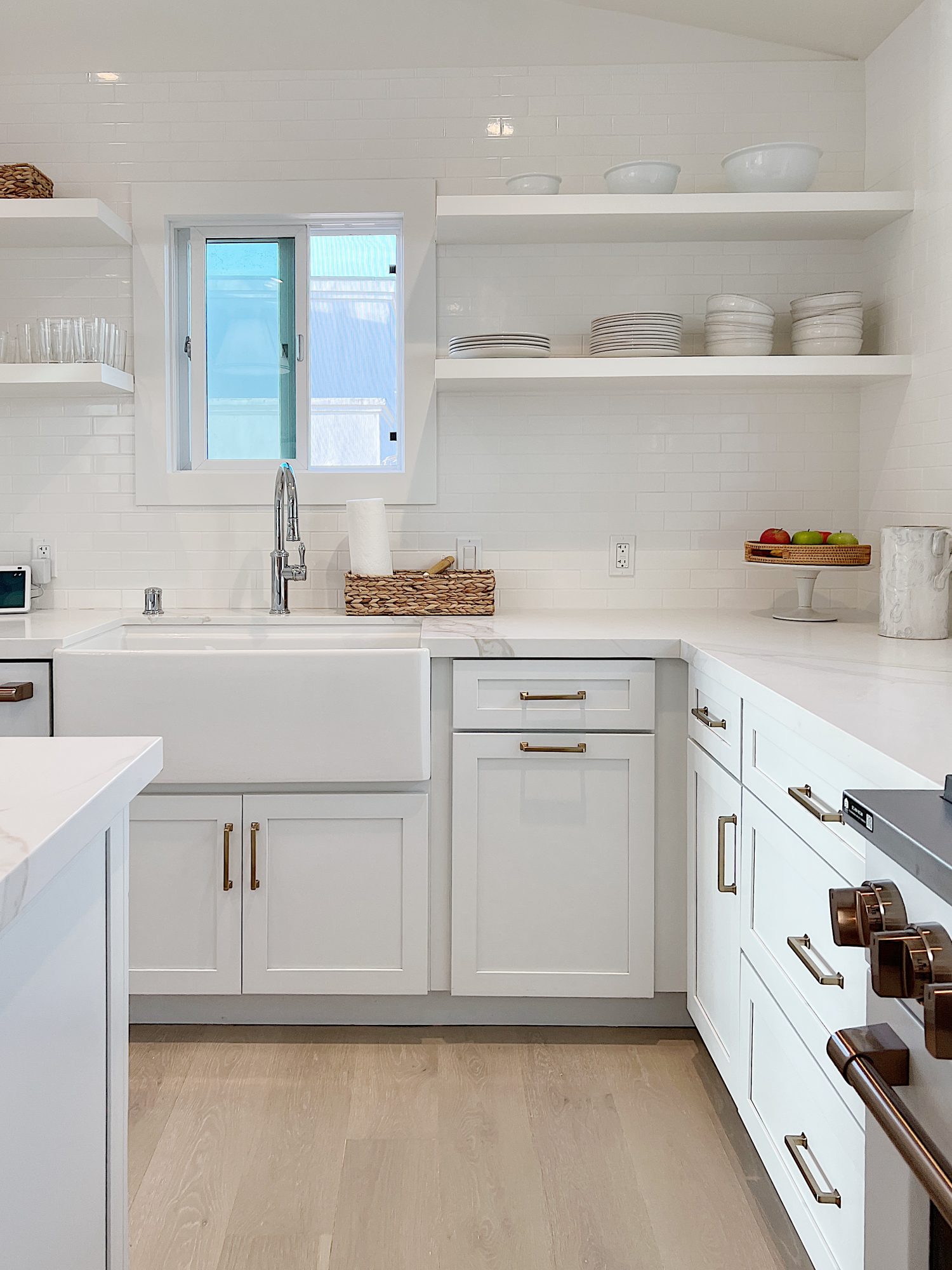 white beach house kitchen with island, countertops, white cabinets, and new lighting.