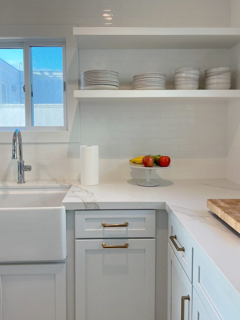 white kitcehn with white cabinets, countertops and open shelves