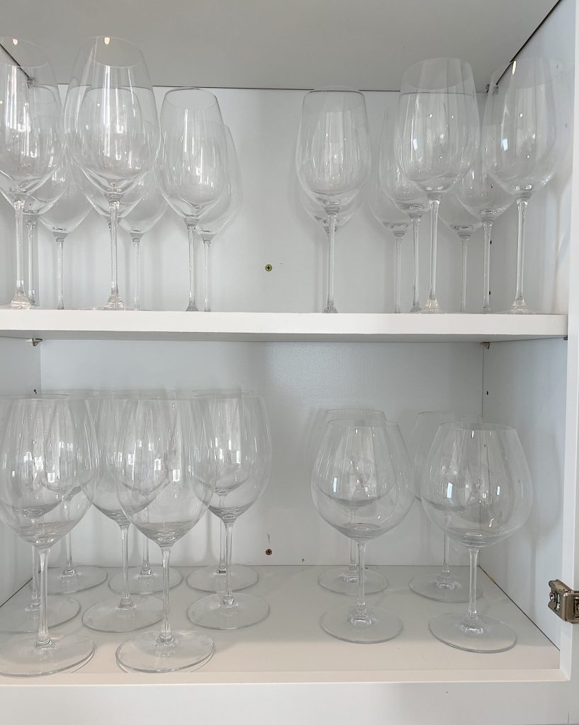 Shelves in the beverage area of the kitchen with Riedel wine glasses