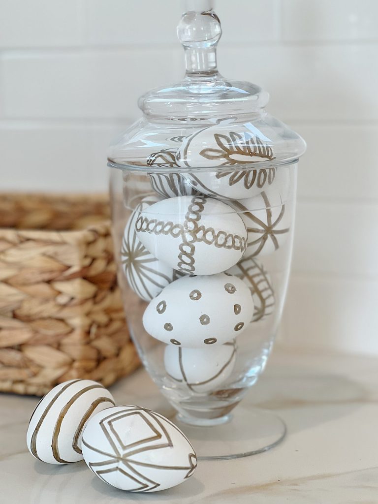 White Easter eggs painted with a copper sharpie pen and placed in an apothecary jar.
