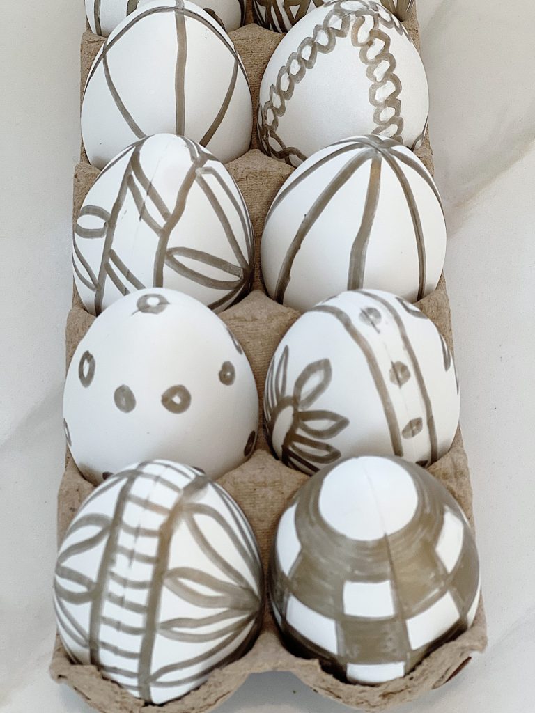 White Easter eggs painted with a copper sharpie pen and placed in an egg carton