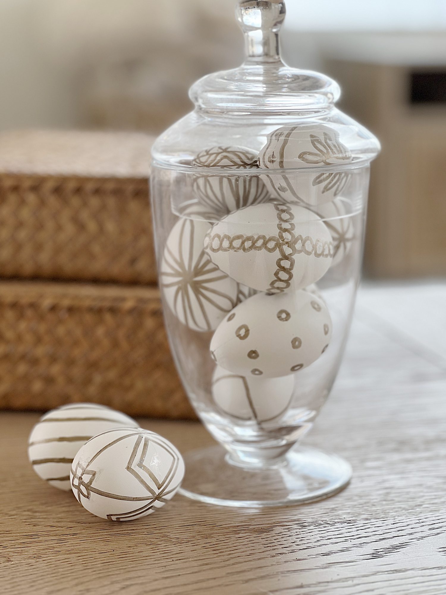 White Easter eggs painted with a copper sharpie pen and placed in an apothecary jar.