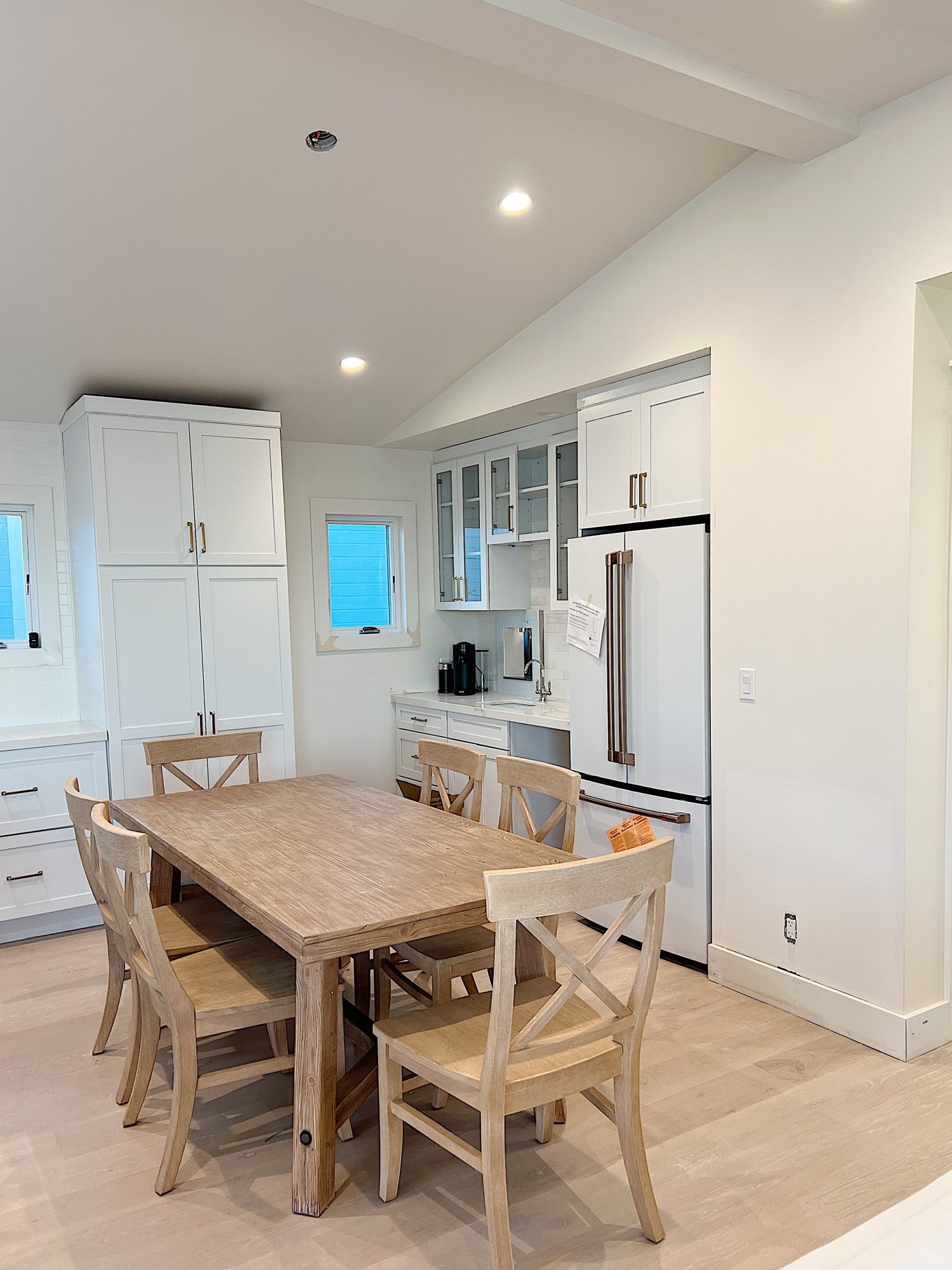 New beach house kitchen. White kitchen with white tile, quarts island, appliances, wood table and white cabinets.
