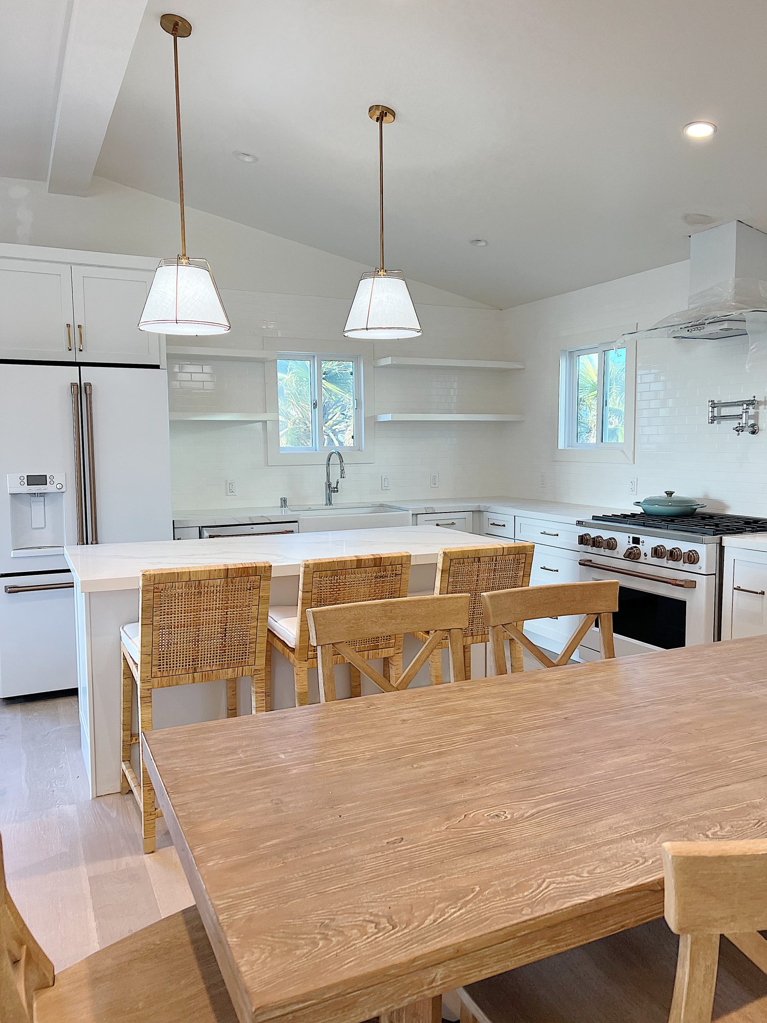 New beach house kitchen. White kitchen with white tile, quarts island, appliances, wood table and white cabinets.