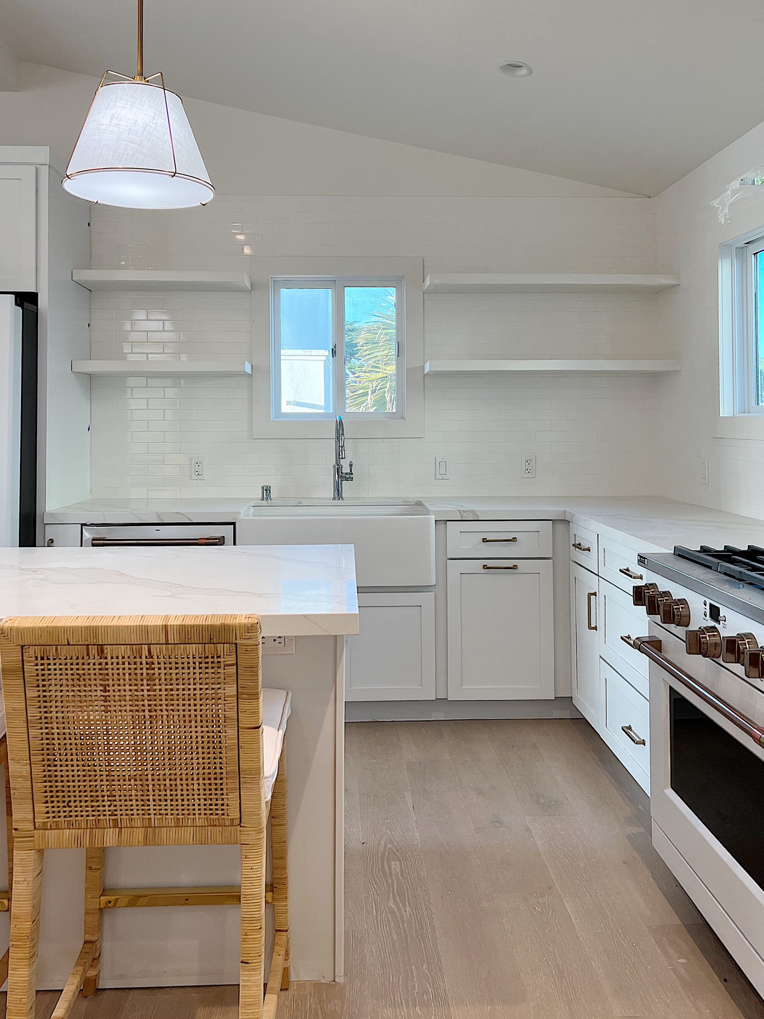 New beach house kitchen. White kitchen with white tile, quarts island, appliances, wood table and white cabinets.