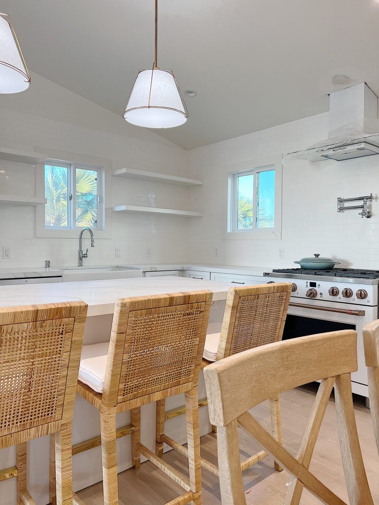 New beach house kitchen. White kitchen with white tile, quarts island, appliances, wood table and white cabinets.