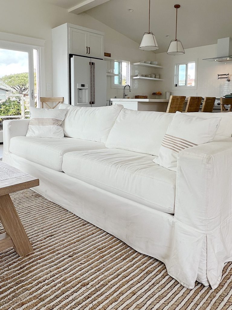 long white couch with two striped pillows in a living area
