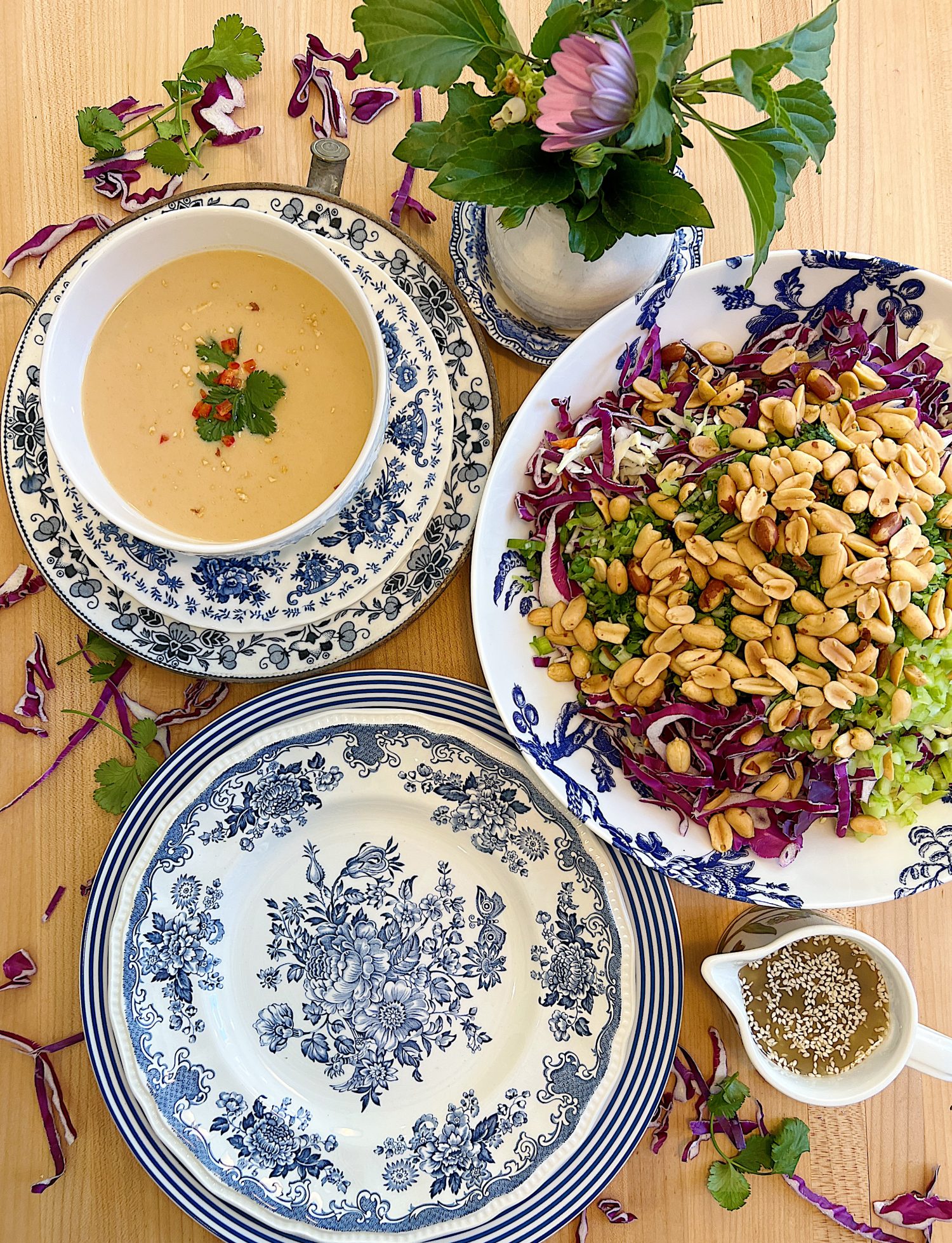 A peanut soup in a blue and white bowl and a peanut crunchy peanut coleslaw with a vinaigrette dressing.