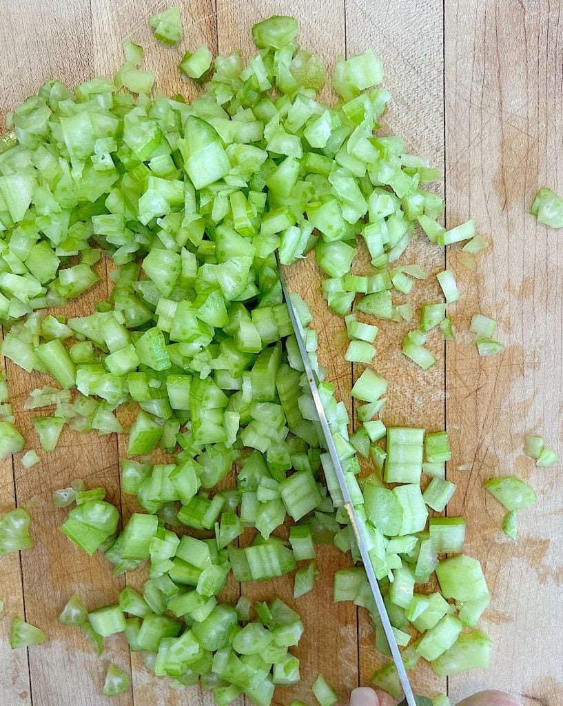 chopping celery on a cutting board with a knife