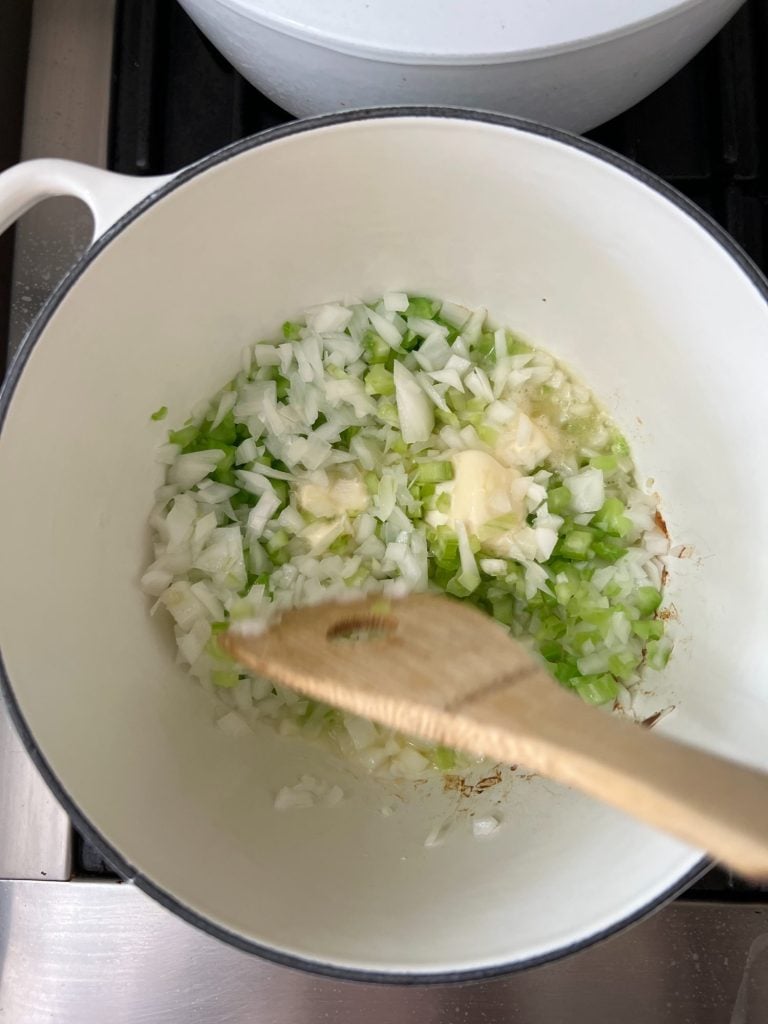 butter and chopped onions and chopped celery cooking in a sauce pan.