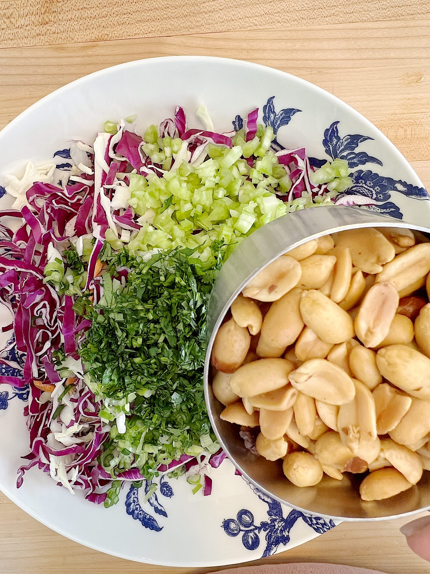 blue and white bowl and a peanut crunchy peanut coleslaw with a vinaigrette dressing.