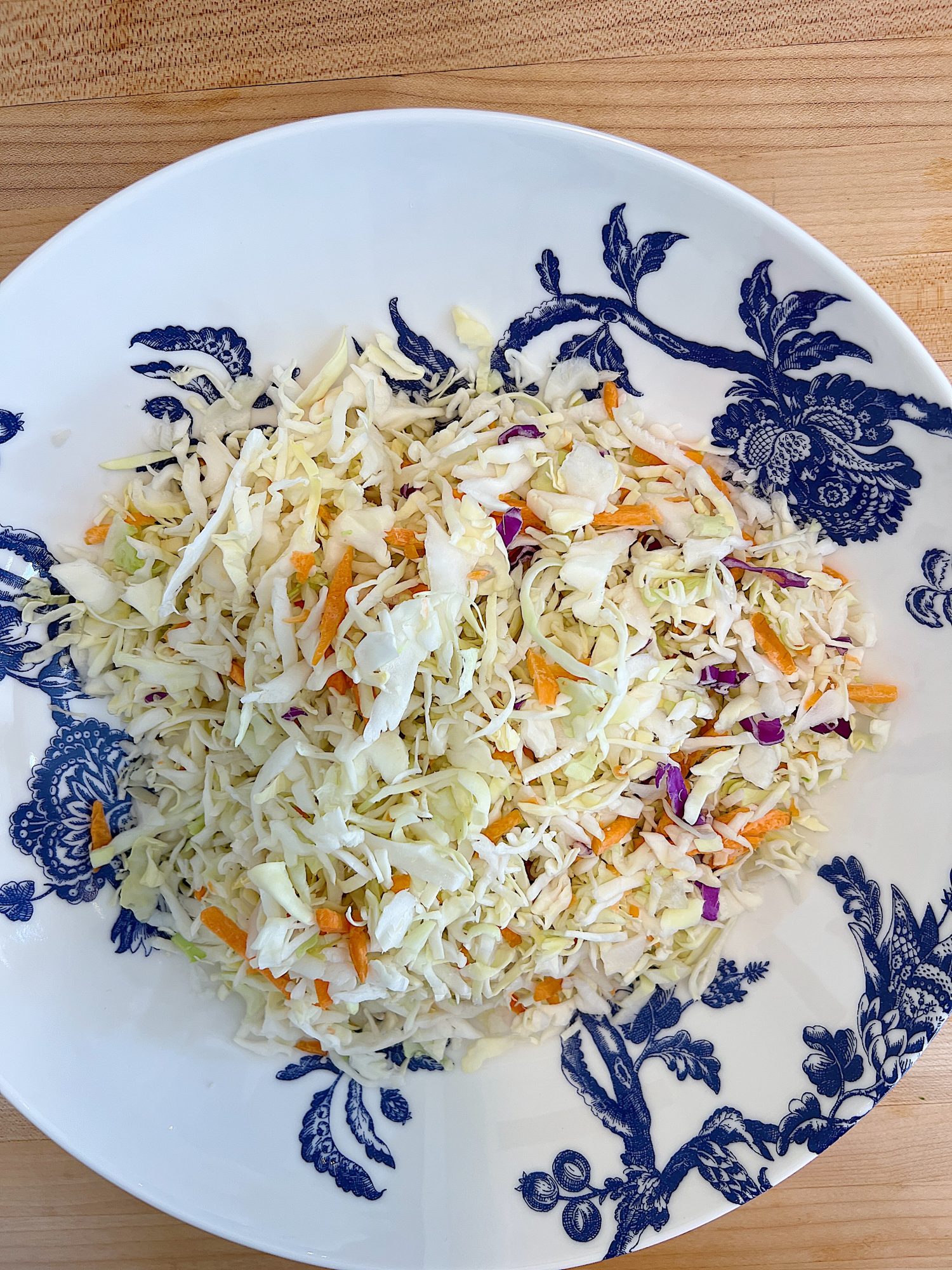 blue and white bowl and a peanut crunchy peanut coleslaw with a vinaigrette dressing.