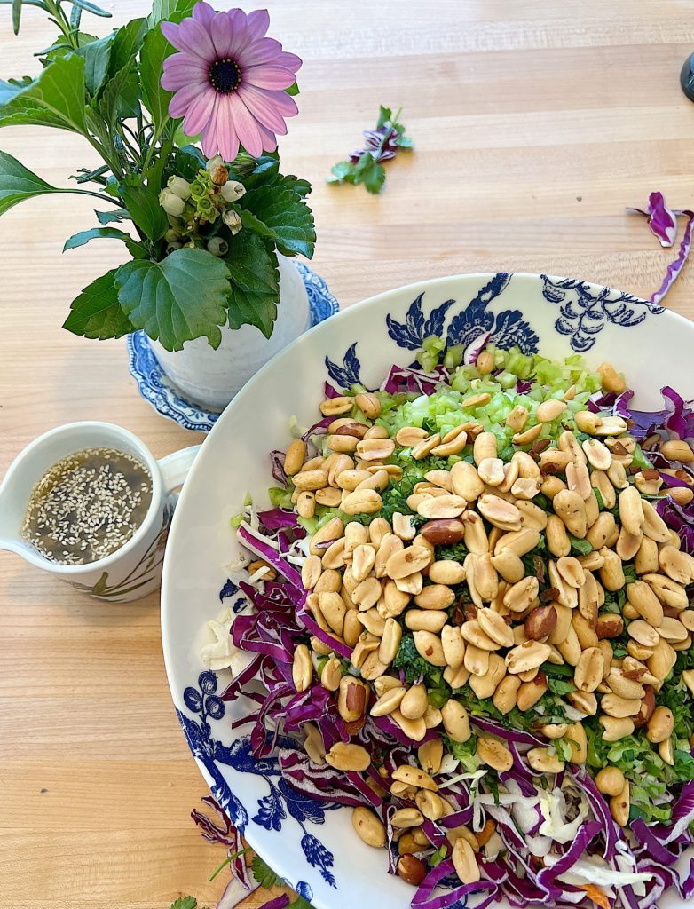 blue and white bowl and a peanut crunchy peanut coleslaw with a vinaigrette dressing.